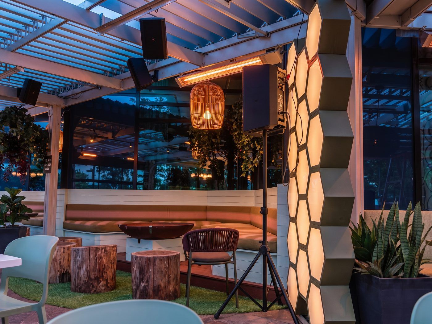 Chauffe-terrasses radiants fixés discrètement sous les poutres d'une pergola en aluminium SunLouvre Pergolas