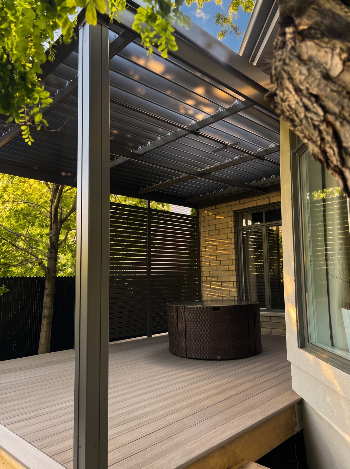 Mur d&rsquo;intimité en aluminium sur un coin de terrasse, la lumière filtre entre les profilés horizontaux