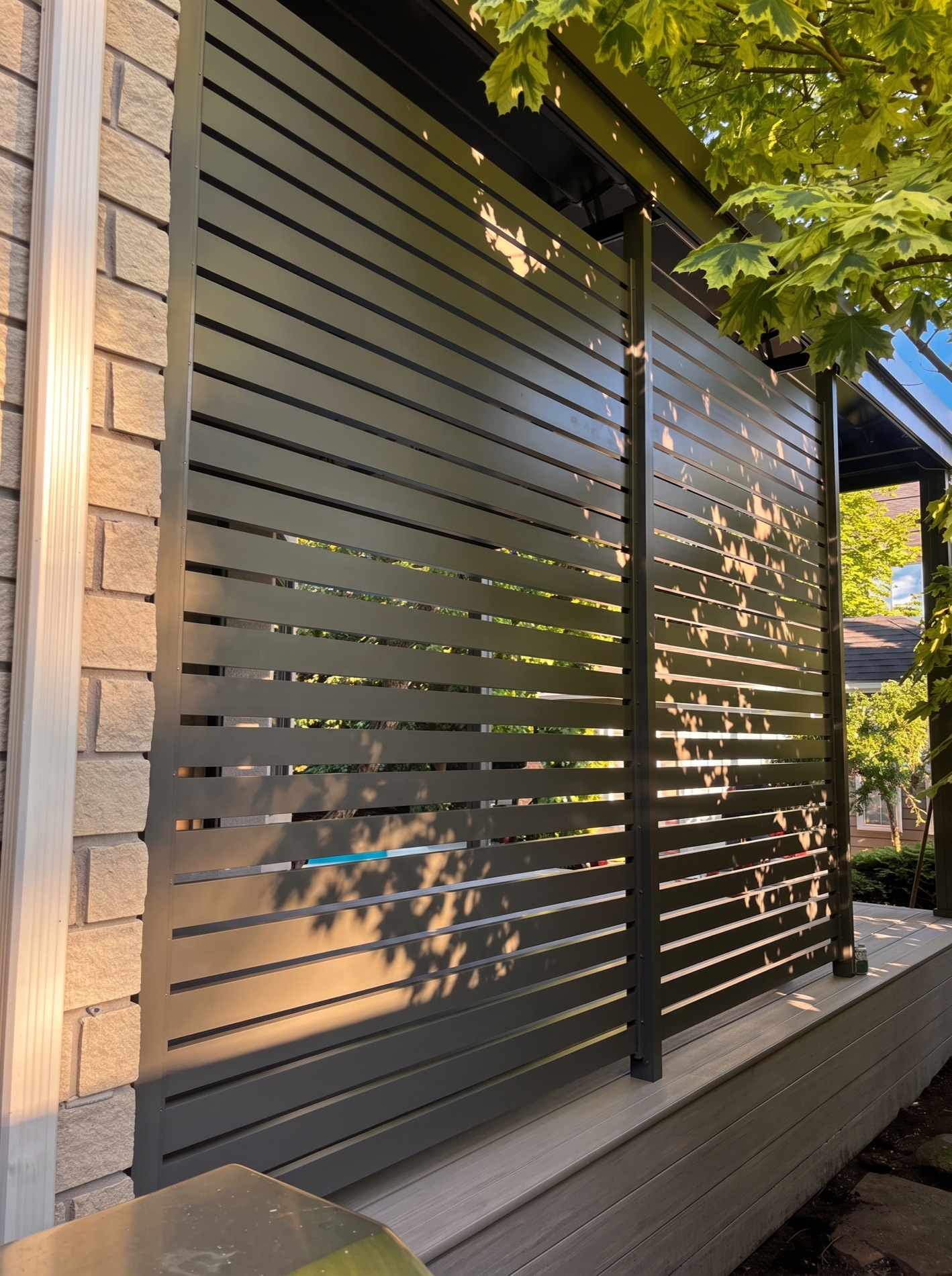 Mur d&rsquo;intimité SunLouvre Pergolas en aluminium, profilés horizontaux traversés par la lumière du soleil