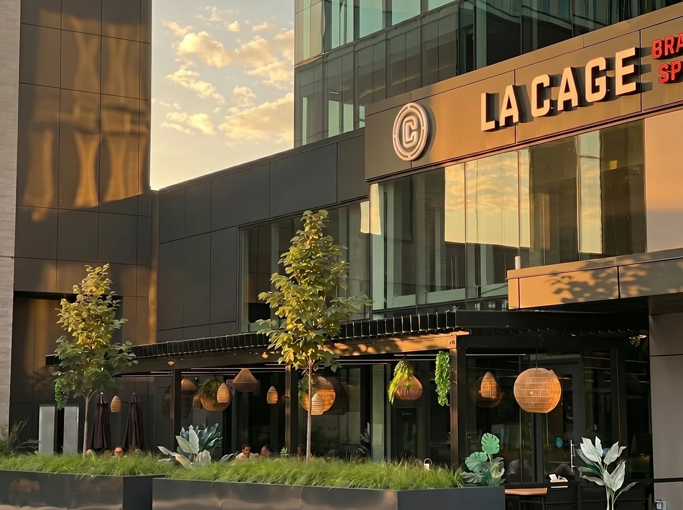 La Cage Brasserie Sportive at Quartier Solar in Brossard with its patio covered by a black SunLouvre Pergolas