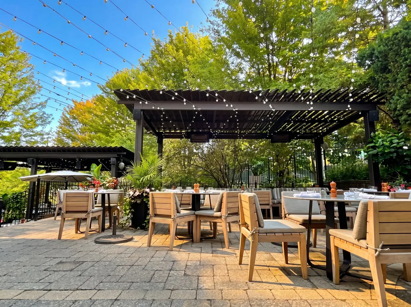 Miller Tavern outdoor patio with black SunLouvre Pergolas and string lights overhead