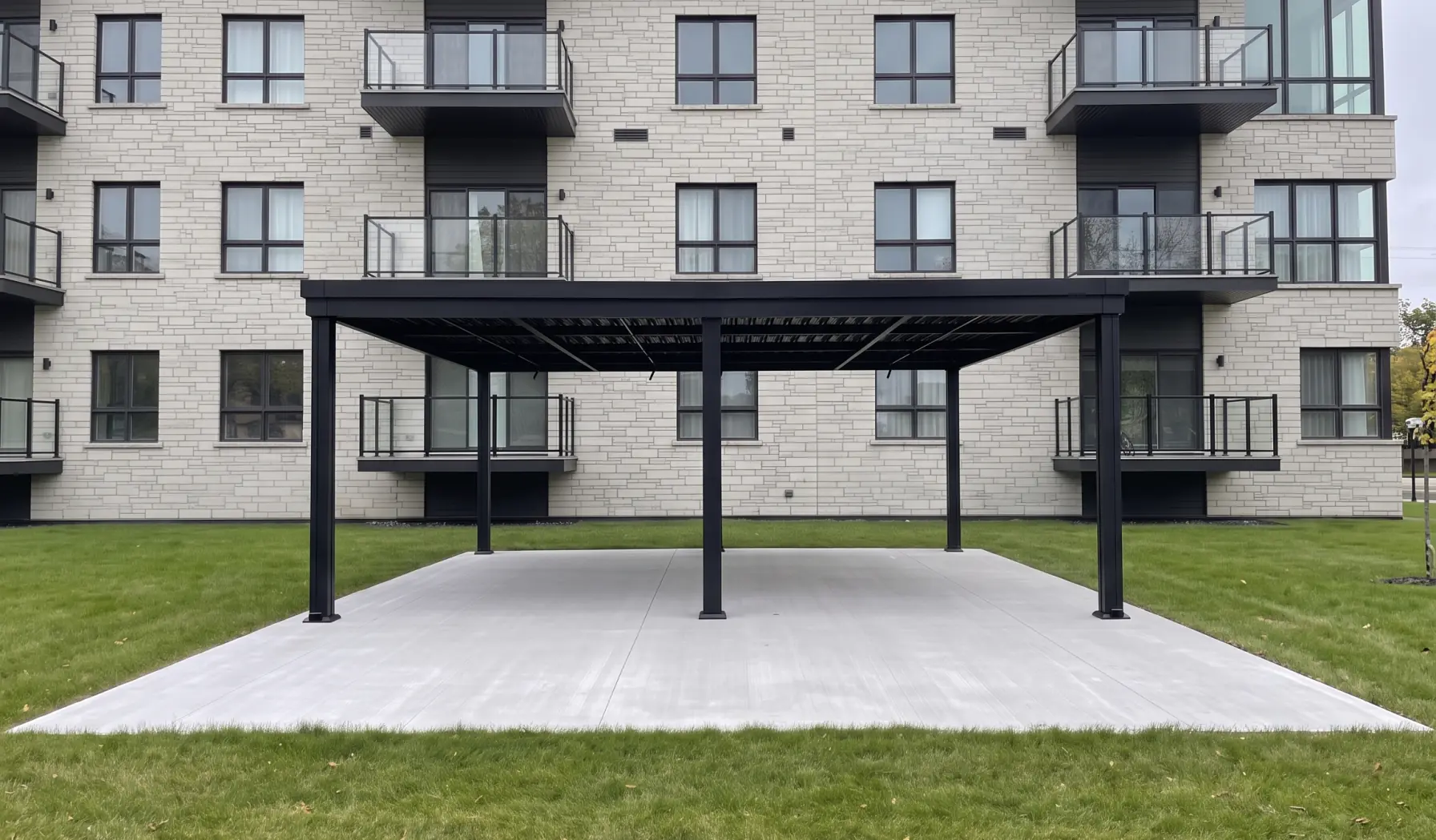 Black pergola on a concrete pad at the foot of the building, Aera Sacré-Coeur in Saint-Hyacinthe