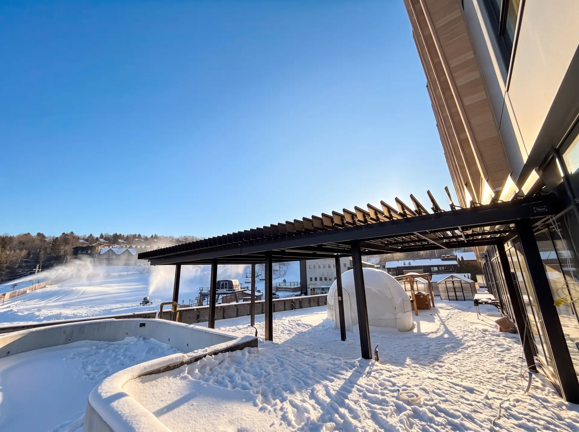 Black pergola over the snowy terrace and its pool, Alpinn in Bromont