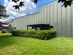 Pergola sombre derrière la haie, le long du bâtiment métallique, Armtex à Magog