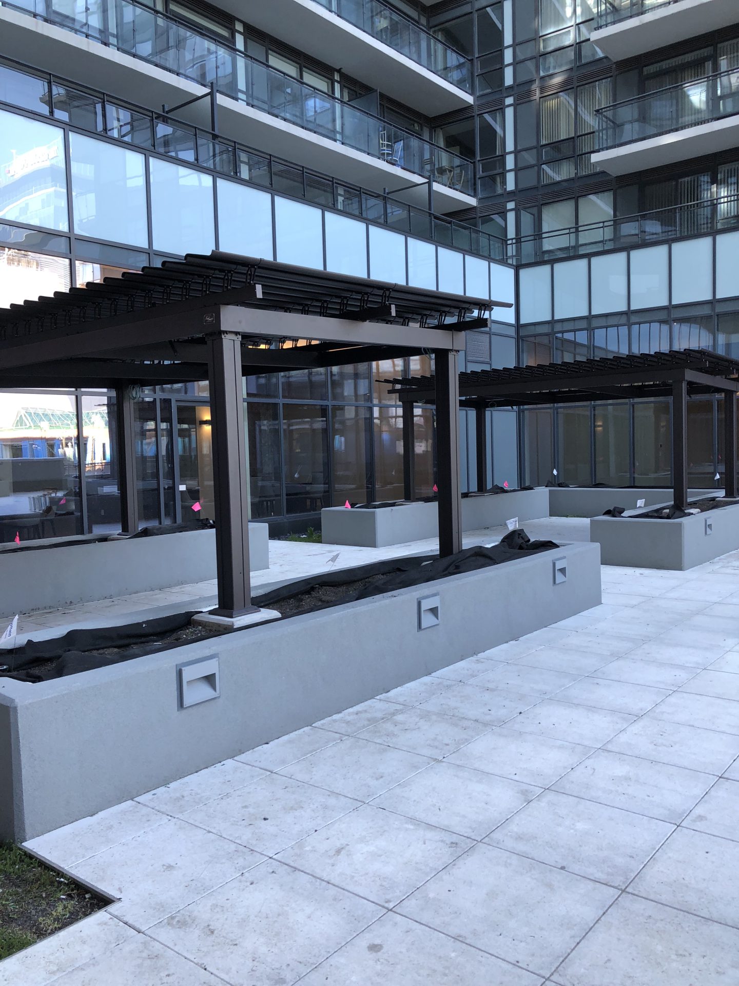 Pergola noire sur la terrasse entre les tours de verre, Axiom Condominiums à Toronto