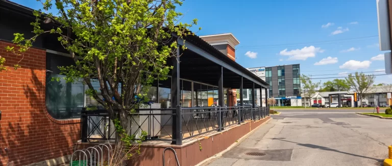 Sheltered terrace running along the brick building, Barbies Resto Bar Grill in Brossard
