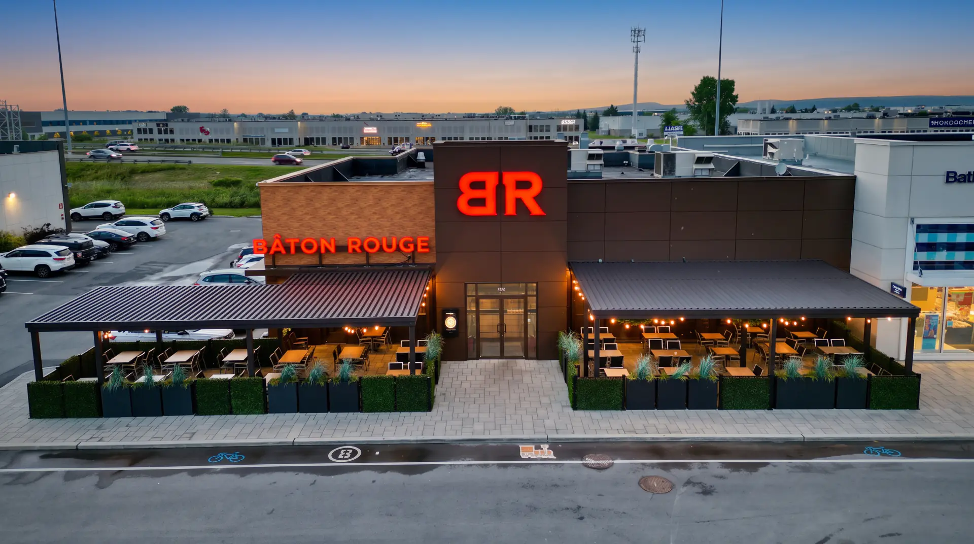 Vue aérienne du restaurant et de sa terrasse couverte au crépuscule, Bâton Rouge à Vaudreuil