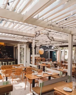 Salle à manger sous un plafond de lames blanches et des guirlandes, Le Boating Club à Laval