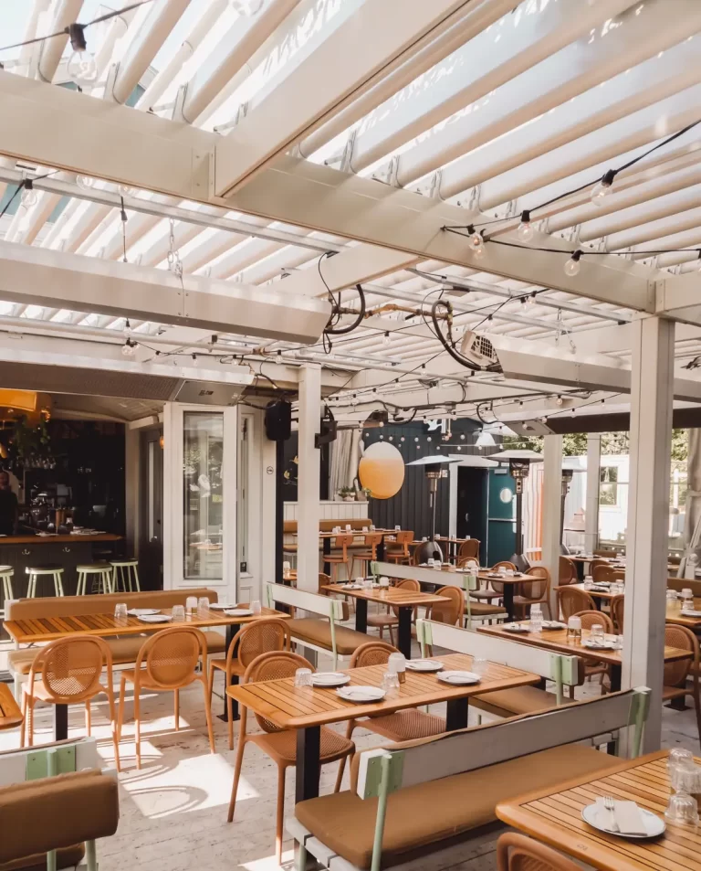 Salle à manger sous un plafond de lames blanches et des guirlandes, Le Boating Club à Laval