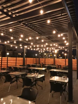 Intérieur de la terrasse couverte, guirlandes allumées le soir, Buon Gusto à Laval
