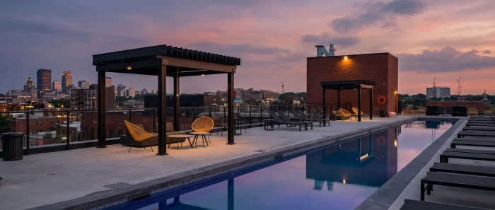 Piscine de toit au coucher du soleil et pergolas noires face à la ville, Esplanade Cartier à Montréal