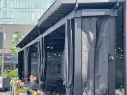 Curtain-enclosed terrace with seated guests, Chez Lionel in Brossard
