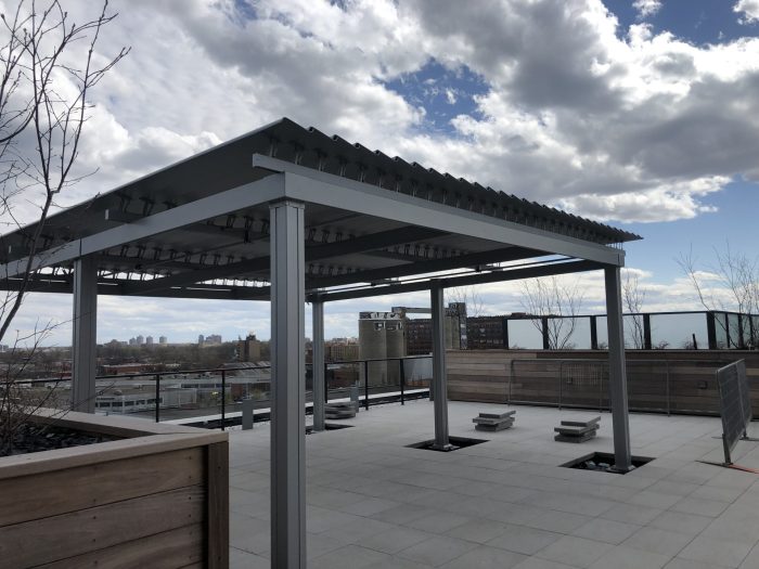 Grey pergola on the roof terrace with its wooden planters, Condos Bassins du Havre in Montréal