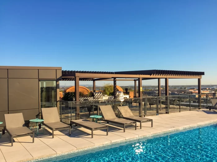 Rooftop pool, loungers and dark pergola, Condos Le Nordelec in Montréal