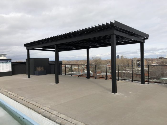 Black pergola on the roof terrace beside the water feature, Condos Walter in Montréal
