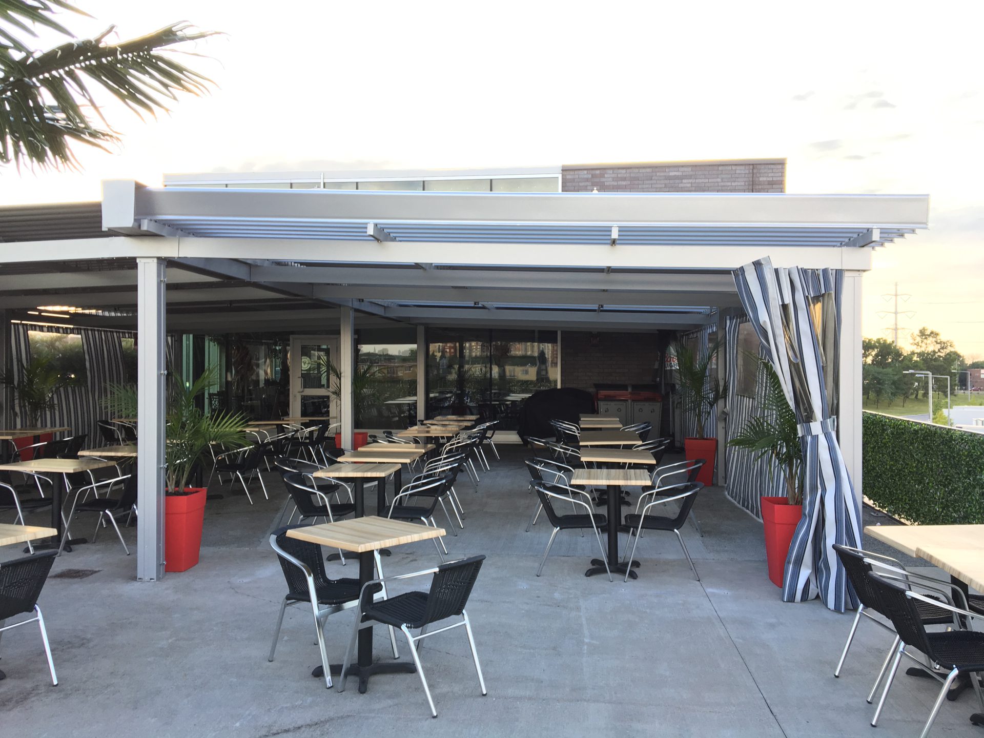 Terrasse blanche fermée de rideaux rayés, Restaurant Cosmopolitain à Saint-Léonard
