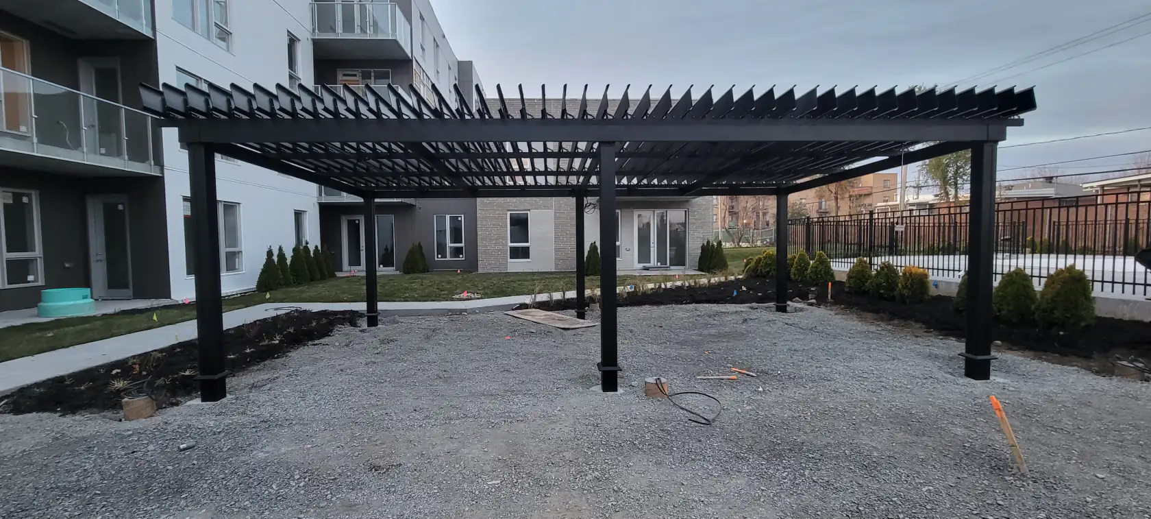 Pergola noire au-dessus de la cour au pied de la tour, Tour Curé-Labelle à Laval