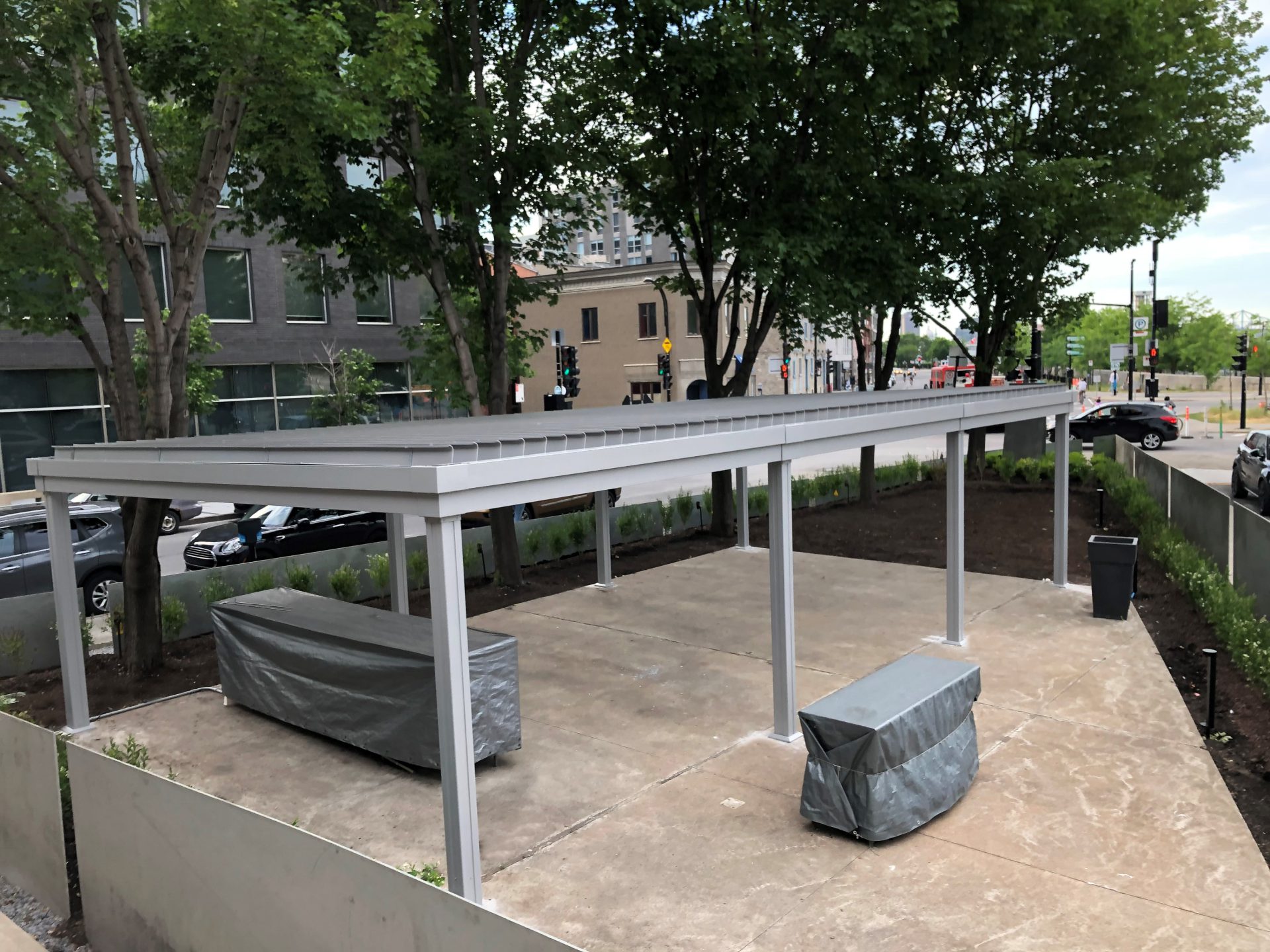 Pergola grise au-dessus de la terrasse de béton en chantier, Restaurant Da Emma à Montréal