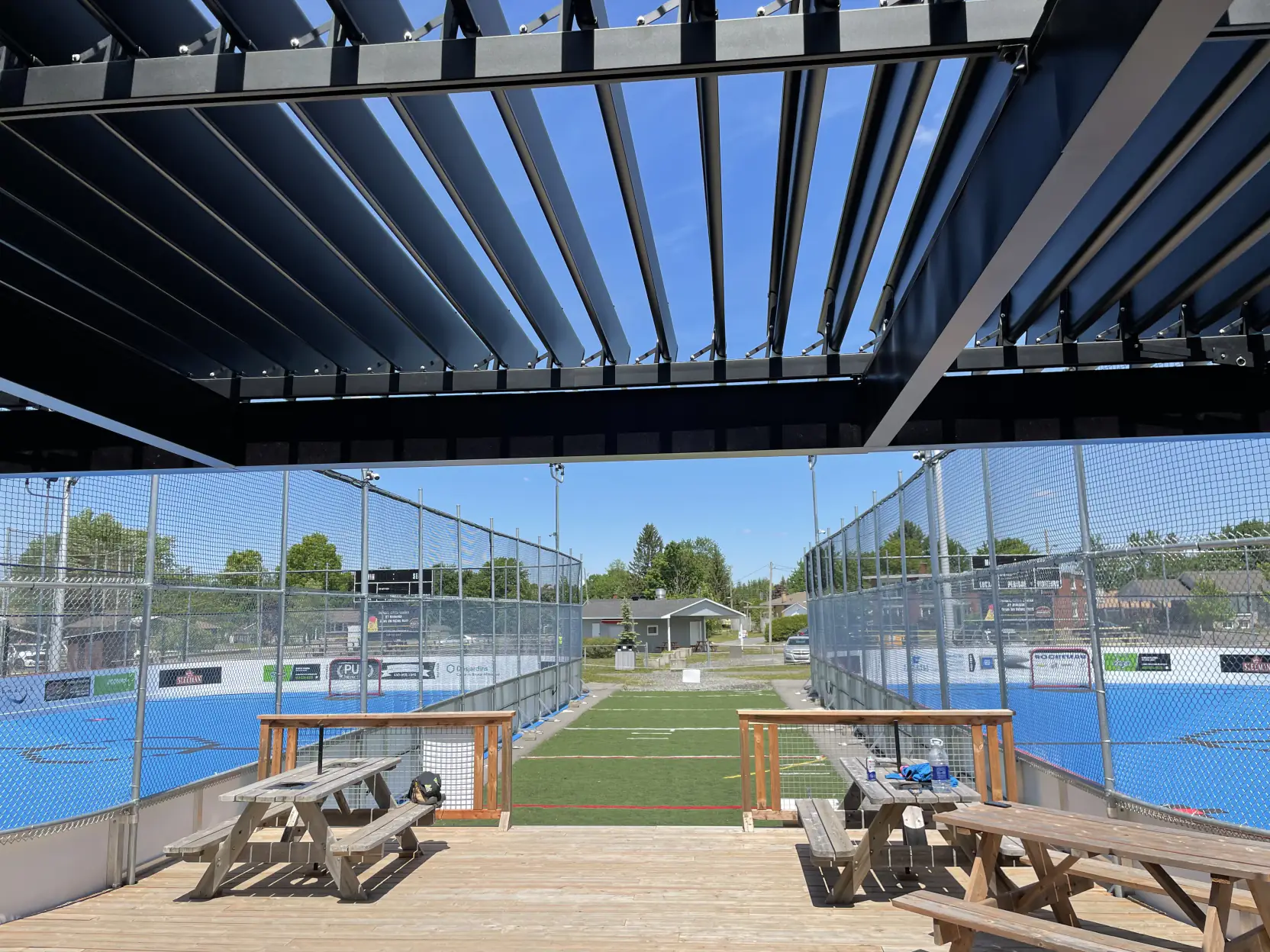 Pergola noire au-dessus des tables en bordure de la patinoire, Dek Hockey Cowansville