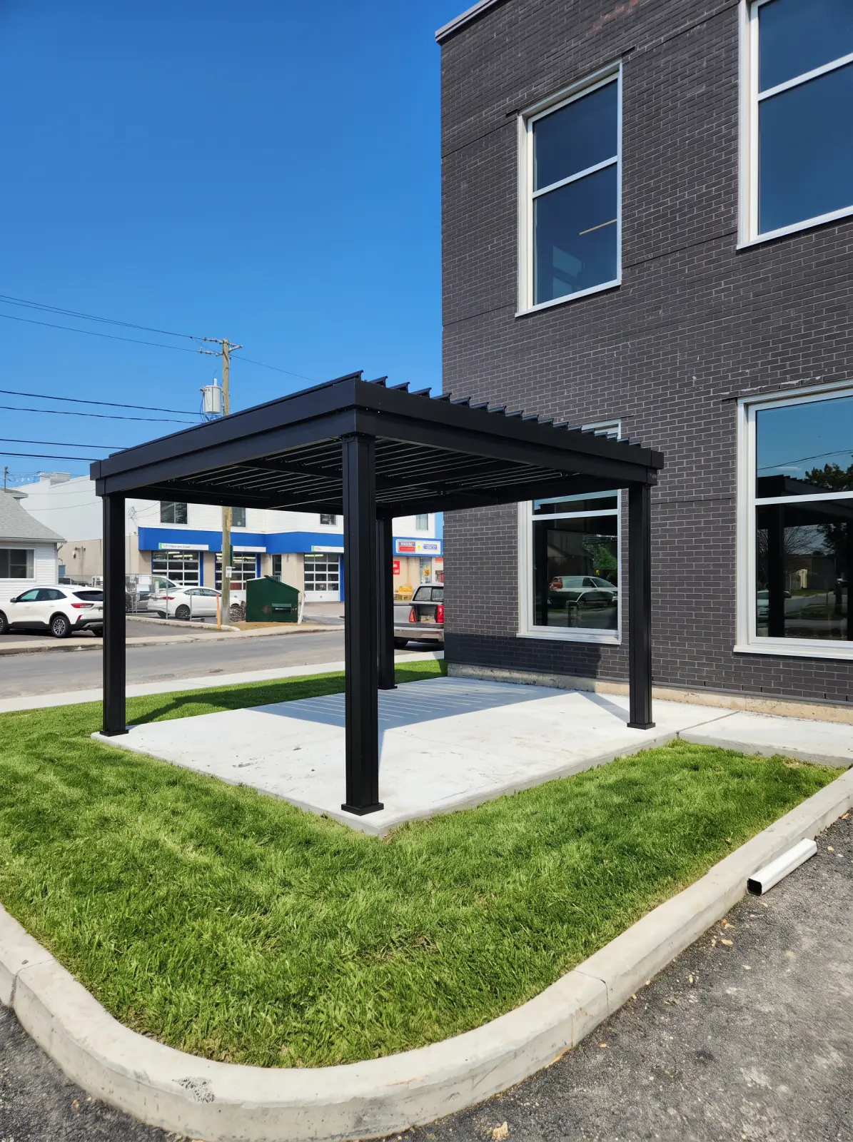 Black pergola on the lawn at the foot of the building, Caisse Desjardins de La Prairie