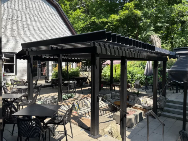 Pergola noire au-dessus de la cour et de ses tables, Domaine Jolivent à Lac-Brome