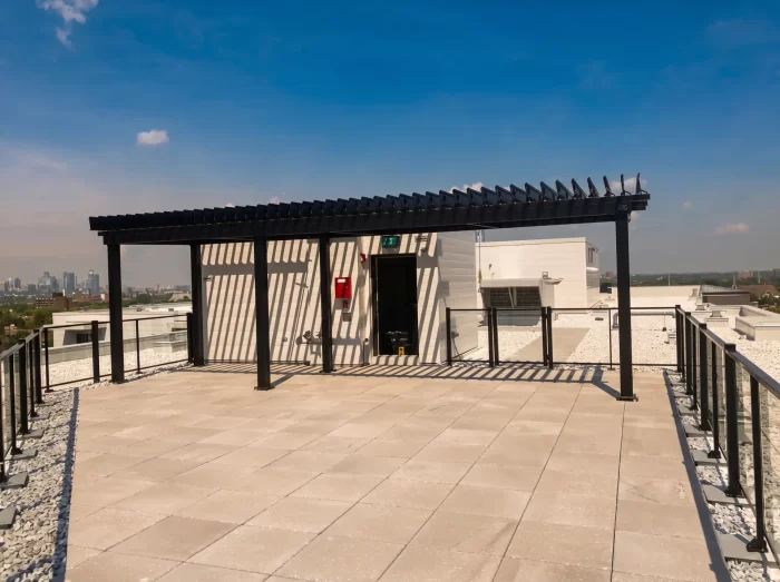 Pergola noire sur la terrasse de toit face à la silhouette de la ville, EQ8 Condos à LaSalle