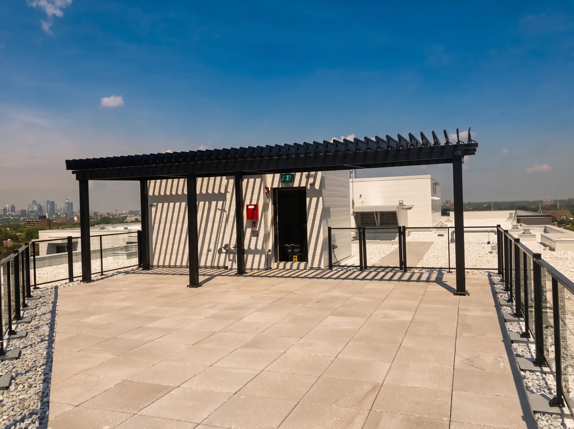 Pergola noire sur la terrasse de toit face à la silhouette de la ville, EQ8 Condos à LaSalle