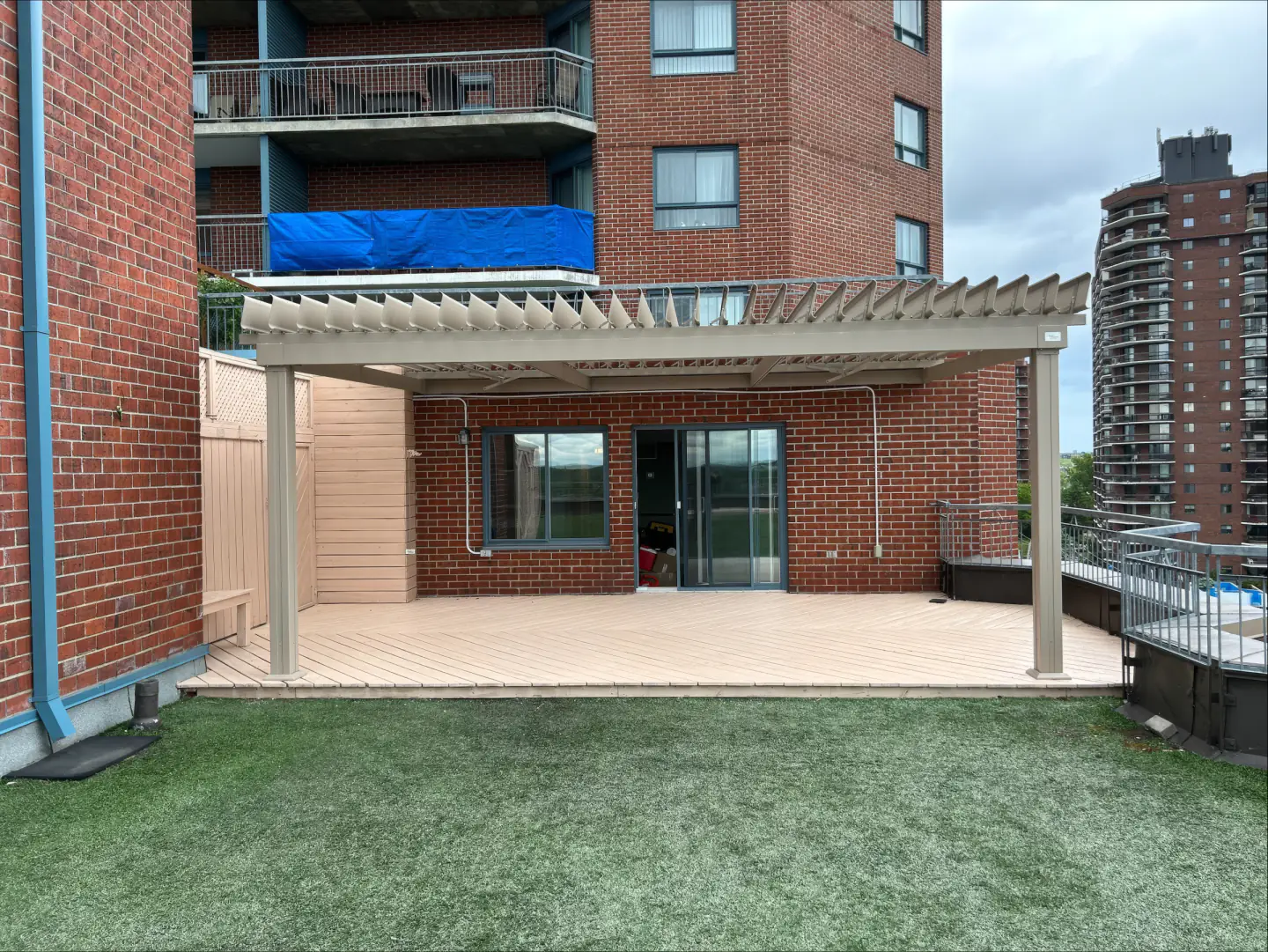 Pergola blanche au-dessus de la terrasse de l'immeuble de brique, Résidence Au Fil de l'Eau à Montréal