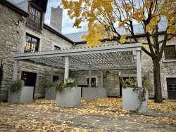 Pergola blanche dans la cour de pierre en automne, Gibbys à Montréal