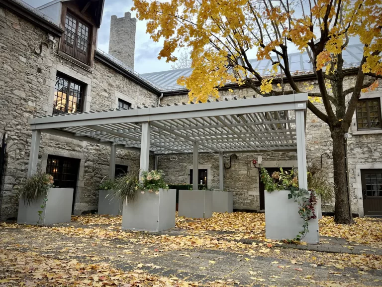 Pergola blanche dans la cour de pierre en automne, Gibbys à Montréal