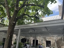 Pergola blanche de la cour de pierre vue sous un grand arbre, Gibbys à Montréal