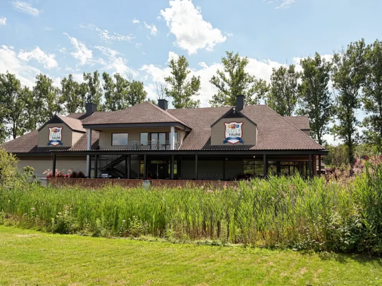 Le pavillon et sa terrasse couverte vus depuis le parcours, Golf de la Faune à Québec