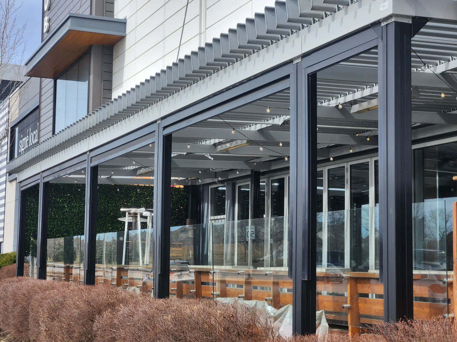Pergola grise au-dessus de la terrasse vitrée, Houston Bar and Grill au DIX30 à Brossard