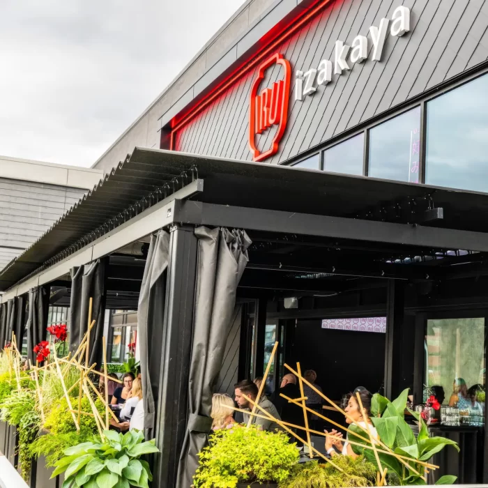 Black pergola and curtains over the terrace, beneath the sign, Iru Izakaya in Sainte-Foy