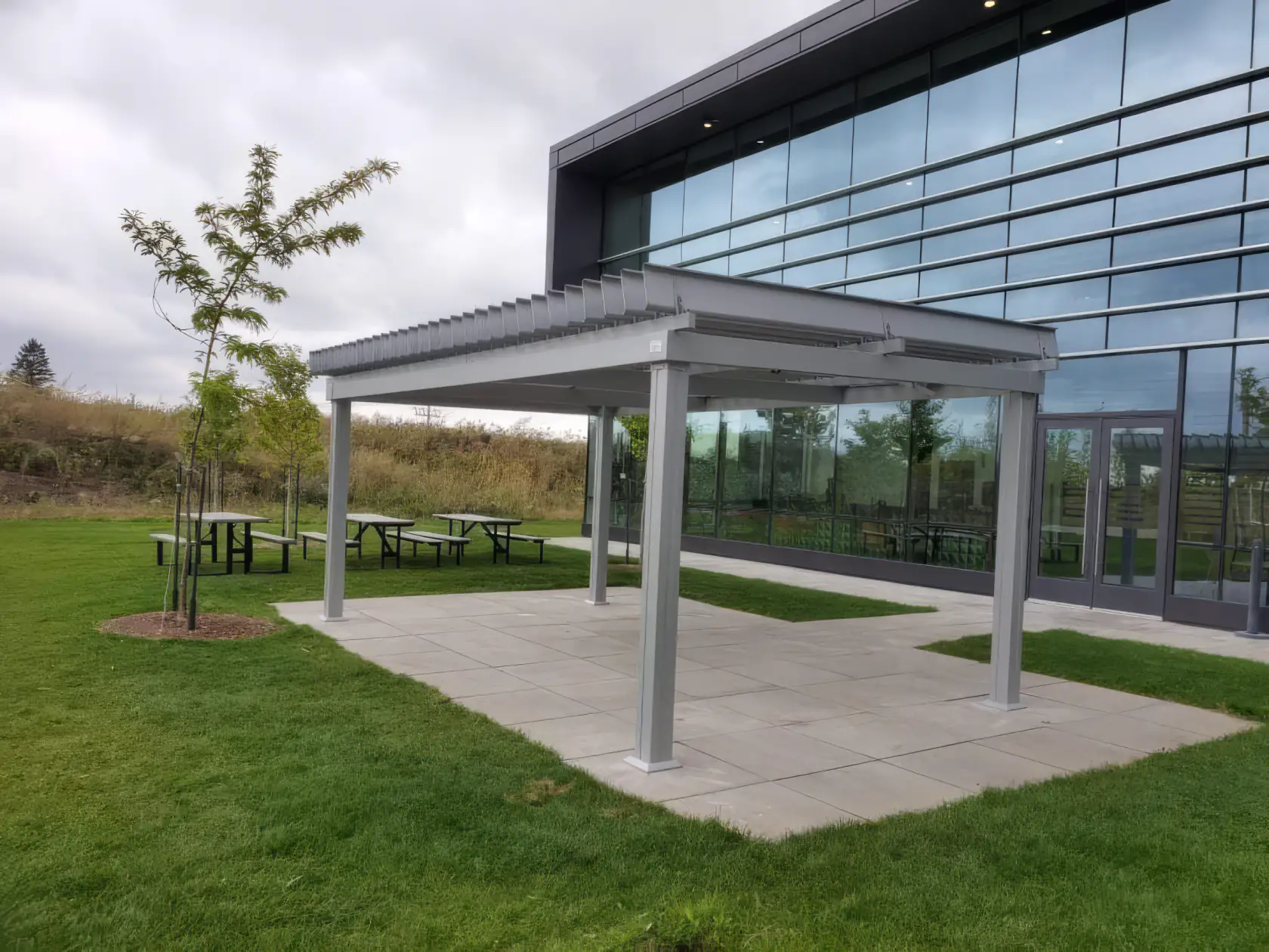 Pergola blanche sur dalle de béton près du bâtiment vitré, ISAAC Instruments à Saint-Bruno-de-Montarville