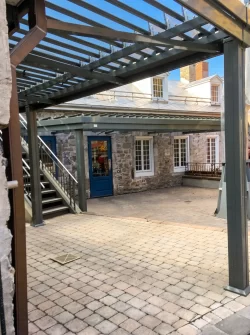 Cour pavée et murs de pierre sous les lames, Jardin Nelson à Montréal