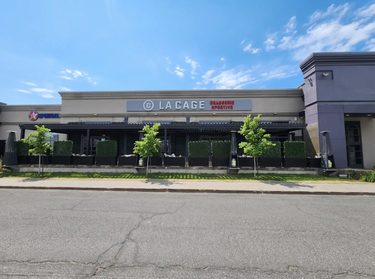 Black pergola along the façade seen from across the street, La Cage in Boucherville