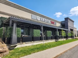 Terrace lined with hedges and patio heaters under the pergola, La Cage in Boucherville