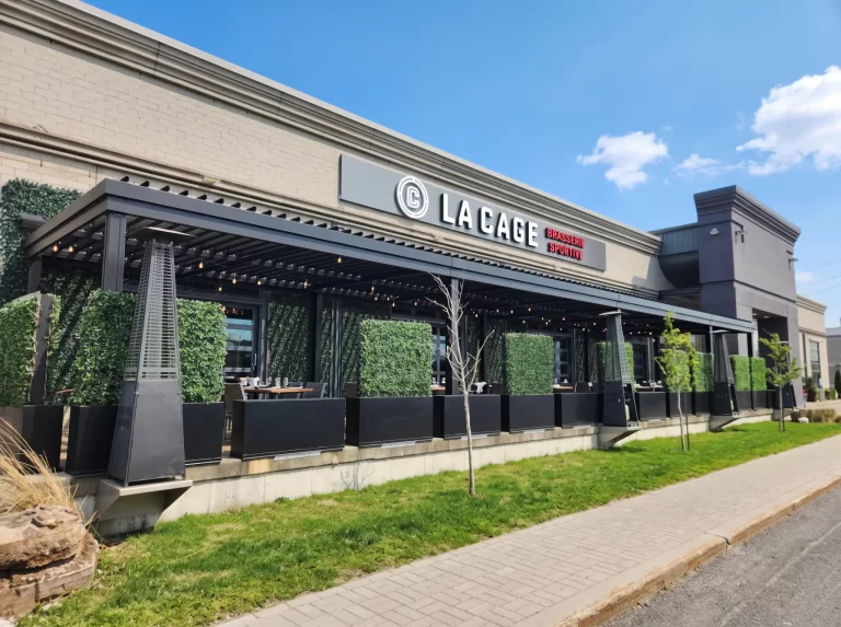 Terrace lined with hedges and patio heaters under the pergola, La Cage in Boucherville