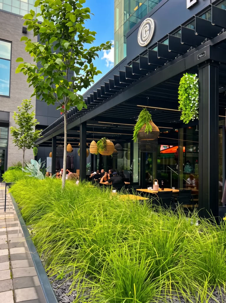 Sheltered terrace seen from the sidewalk and its grasses, La Cage Solar in Brossard