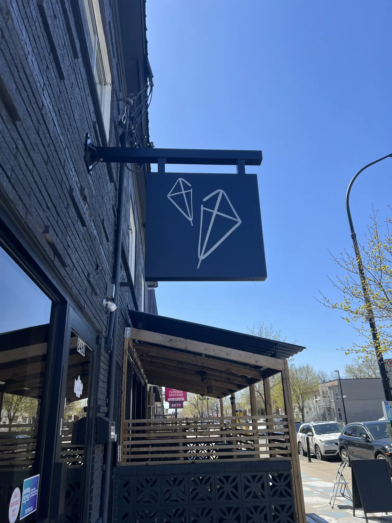 Pergola noire au-dessus de la terrasse sous l'enseigne du bistro, Bistro Le Cerf-Volant à Montréal