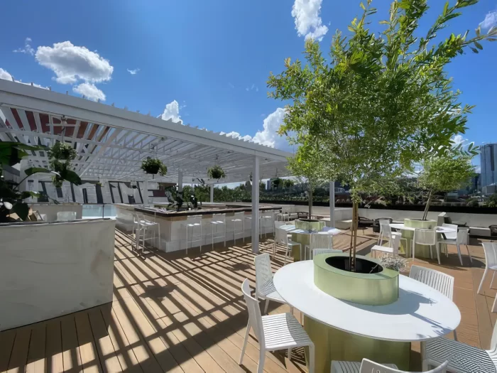 Terrasse de toit avec bar et tables sous une pergola blanche, Le Parloir à Montréal