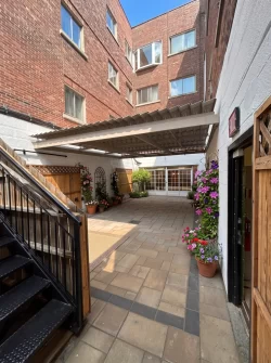 Sheltered courtyard with stairs and flower planters, Résidence Lev-Tov in Montréal