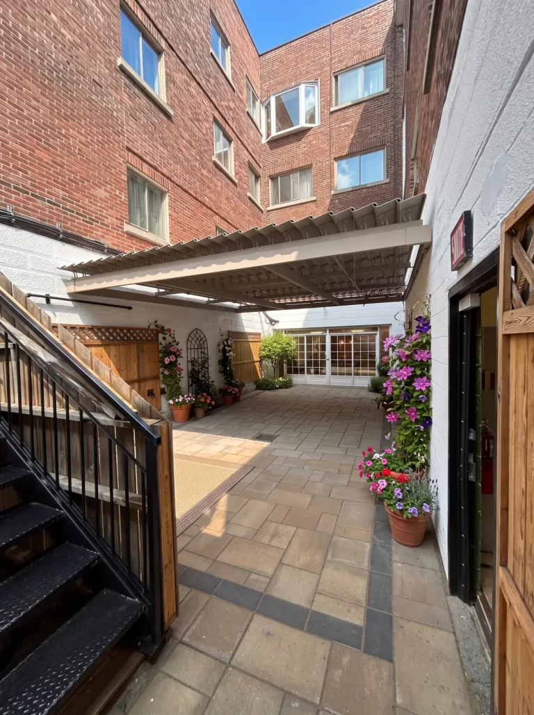 Sheltered courtyard with stairs and flower planters, Résidence Lev-Tov in Montréal