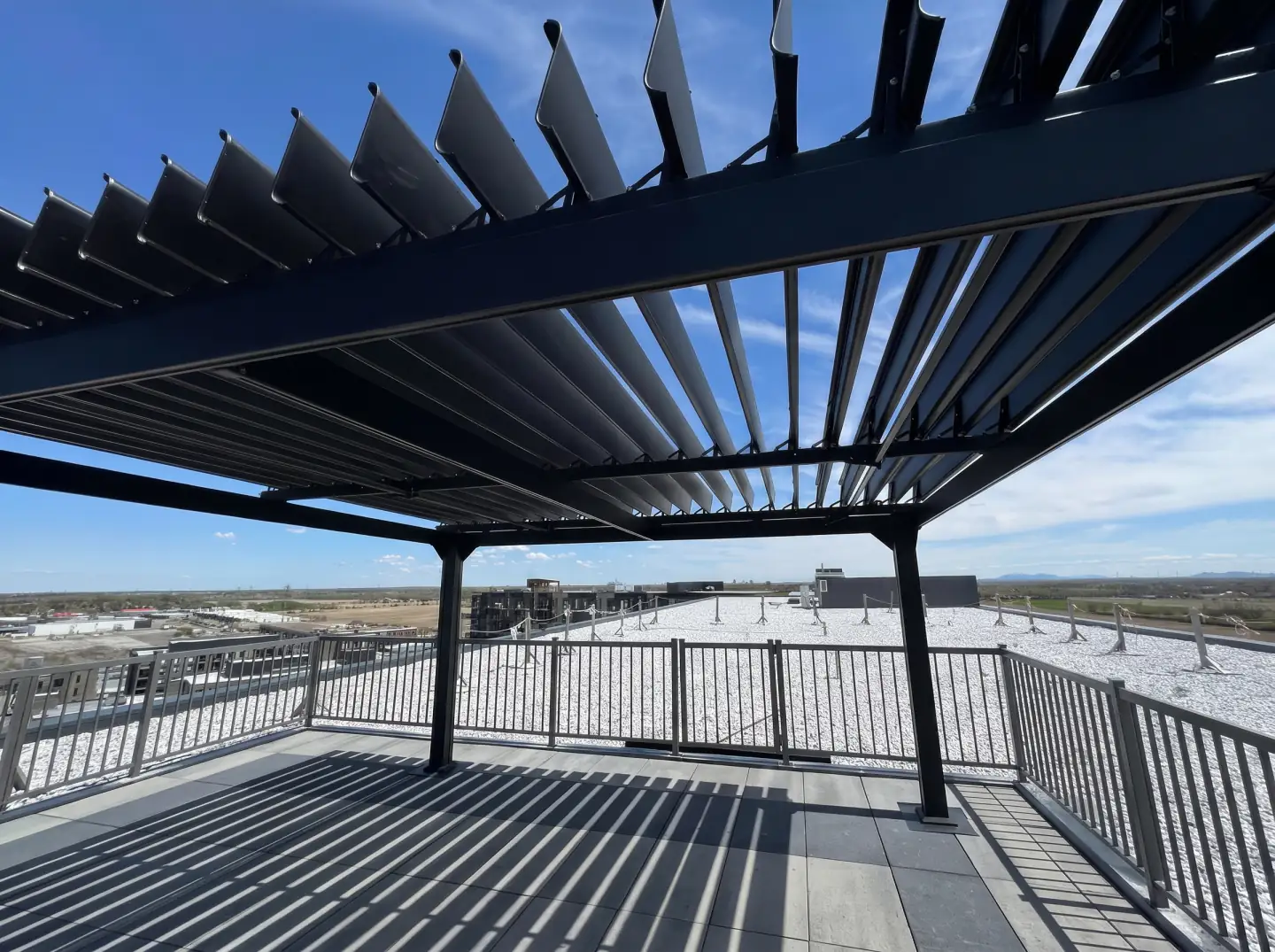 Pergola noire sur la terrasse de toit dominant le secteur, Livéo Condos à Mascouche