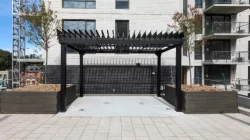 Cour pavée et bacs de plantation sous la pergola noire, Résidence LIZ à Montréal