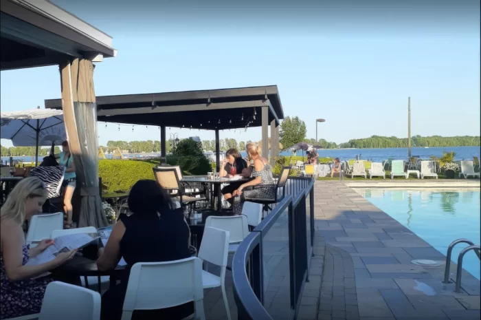 Convives attablés au bord de la piscine face au plan d'eau, Restaurant Marina St-Tropez à Saint-Blaise-sur-Richelieu