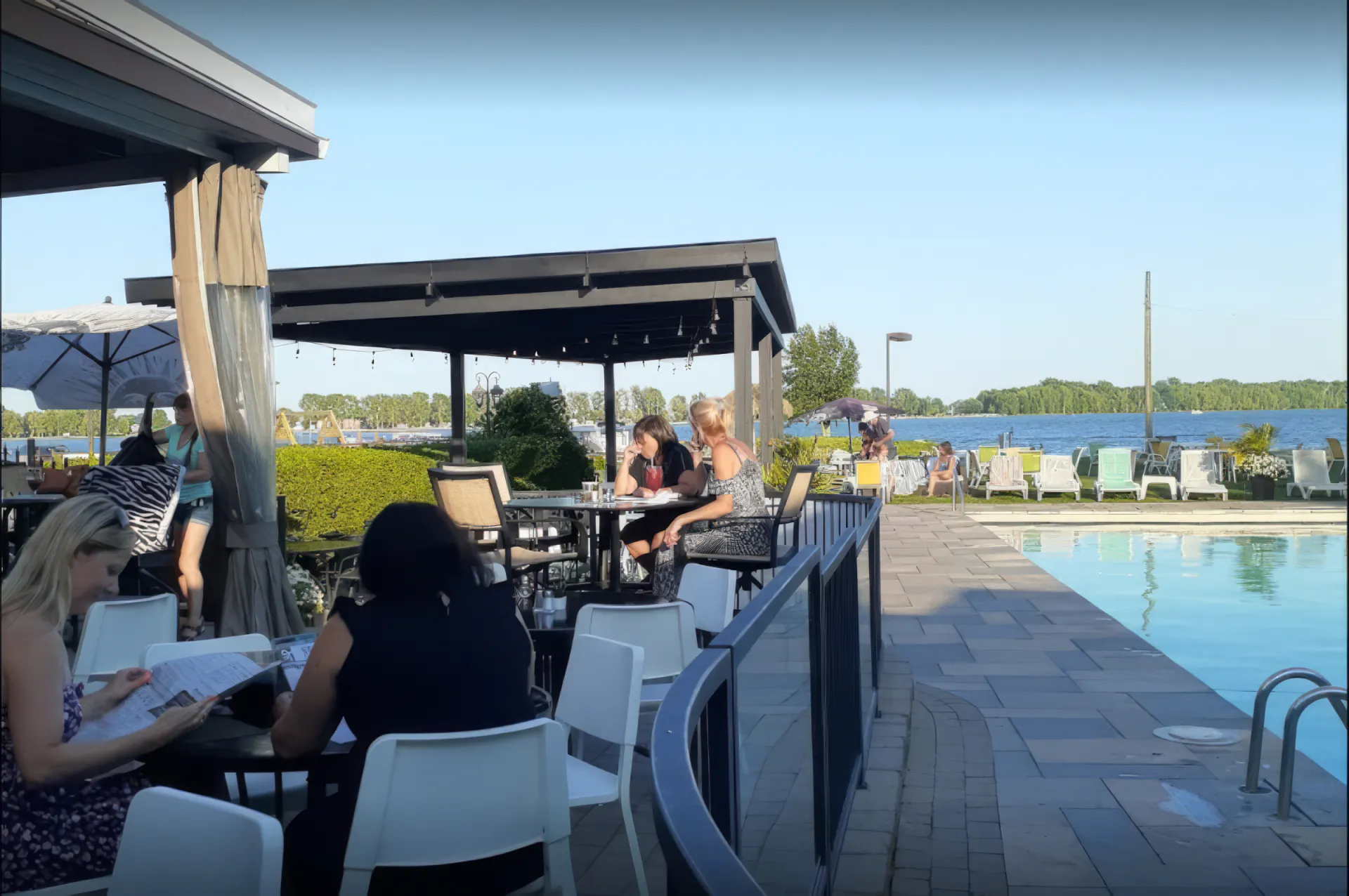 Convives attablés au bord de la piscine face au plan d'eau, Restaurant Marina St-Tropez à Saint-Blaise-sur-Richelieu