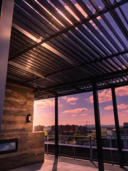 Lames vues de dessous au crépuscule, mur de bois et foyer, Condo La Marquise Phase 2 à Laval