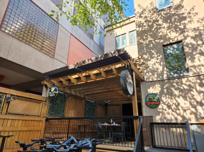 Pergola de bois au-dessus de la terrasse du pub entre les bâtiments, Mckibbin's Irish Pub à Montréal